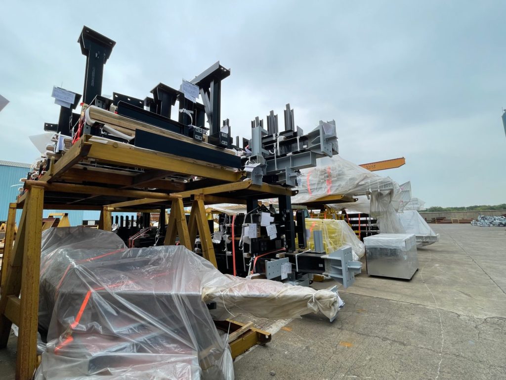 Rows of fabricated steel modules tarped and packed for global export at HENZO